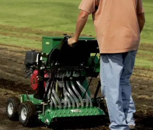 How does a lawn overseeder work?